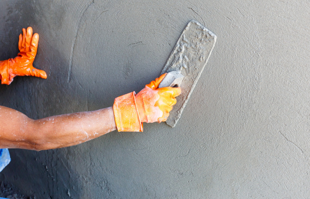 A worker smoothing out a cement wall