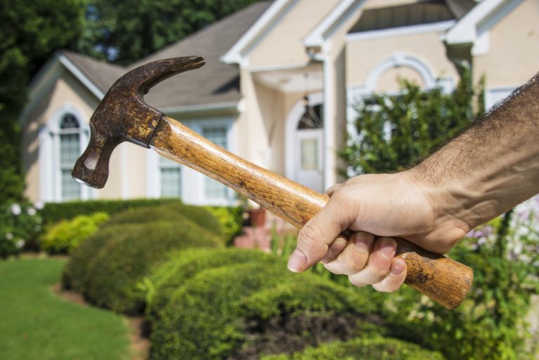 a man holding a hammer for house improvement